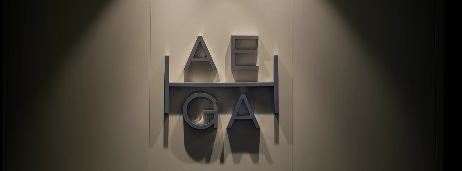 Letras institucionales AEHGA en la sede de la cámara, iluminadas con luz cenital